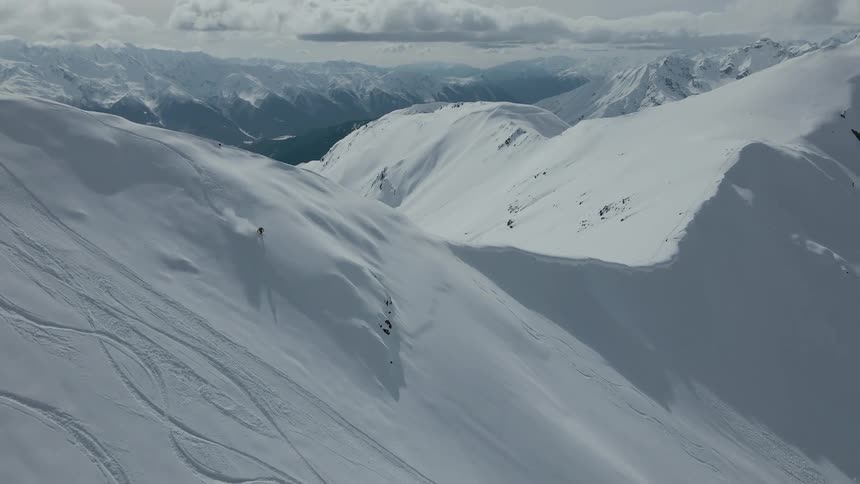 Skier freeriding in the mountain range at midday