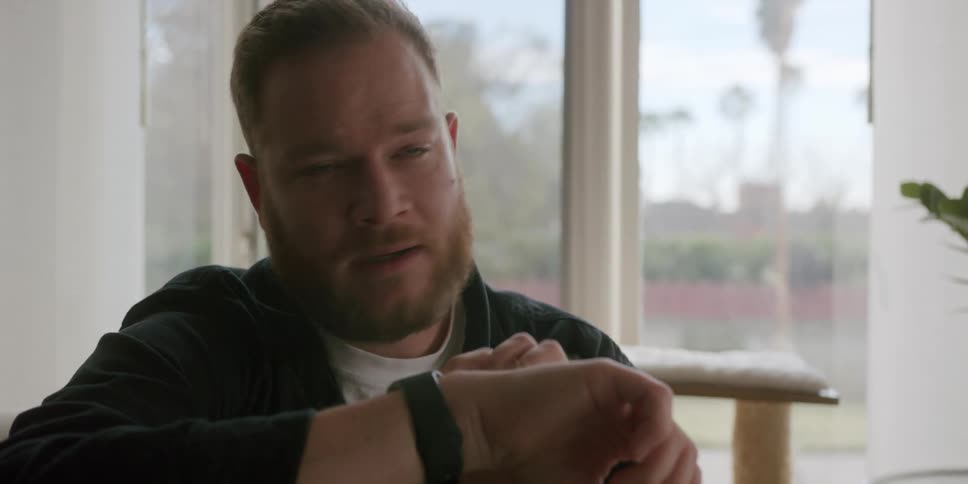 A man talking through a smartwatch in the living room