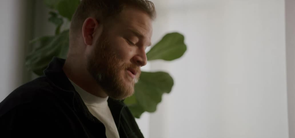 Close up of a man sitting in a room on a sunny day