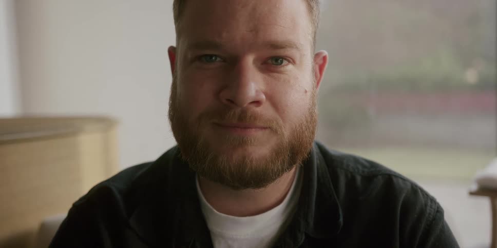 A man is looking forward smiling