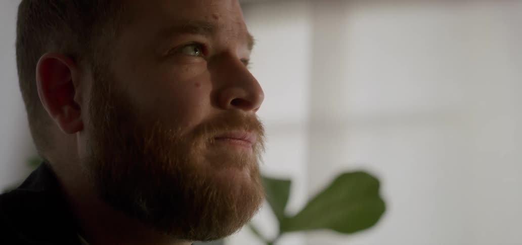 A man sitting in a room looking sad