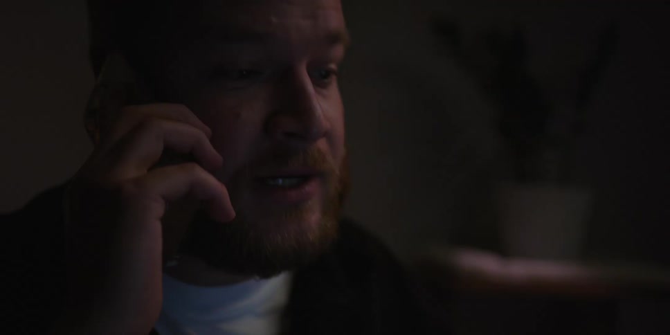 A man talking on a smartphone in a room