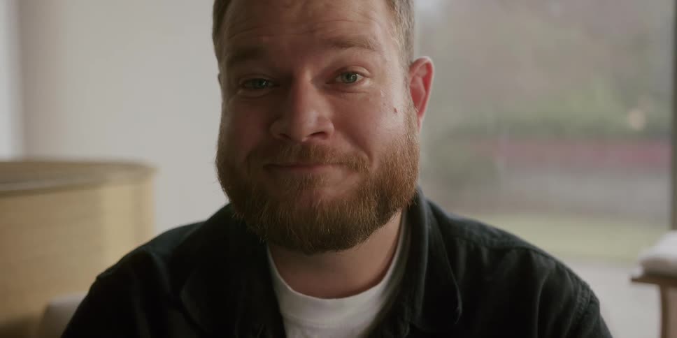 A man is sitting and smiling