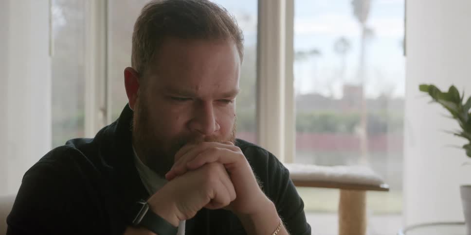 A man is almost crying his hands together next to his face then he gestures and sighs