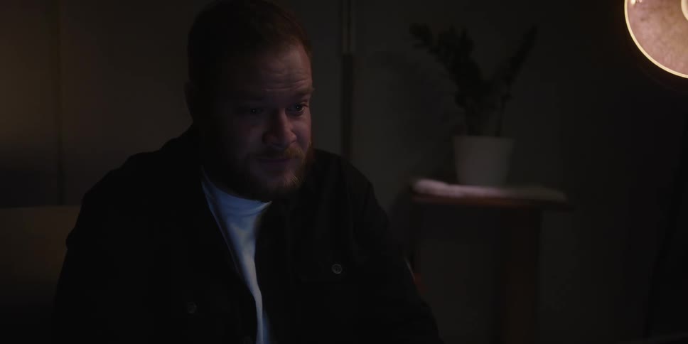 A man sitting in a room looking sad