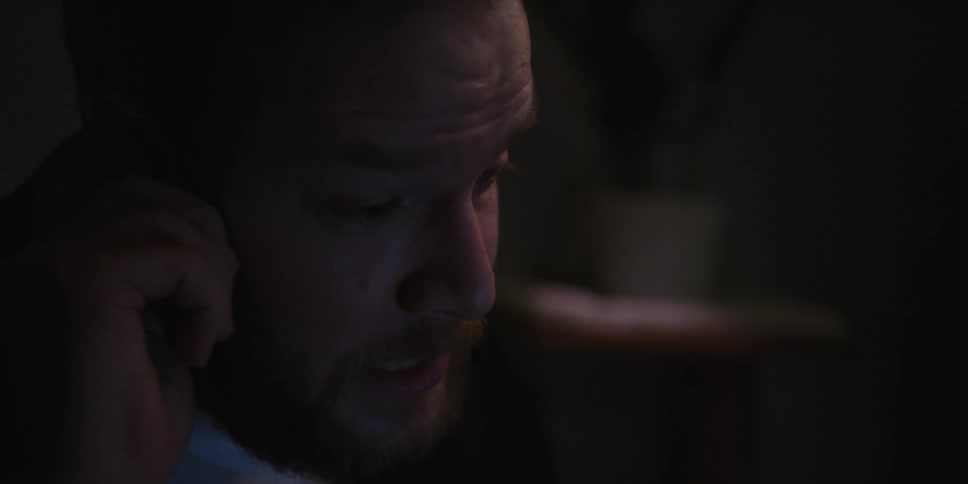 Portrait of a man with a beard in a dark room talking