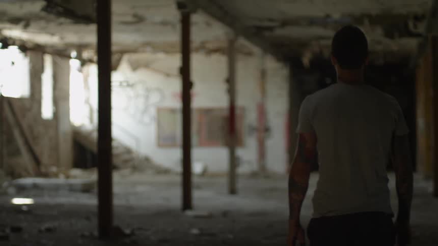 A man walks through a run down building