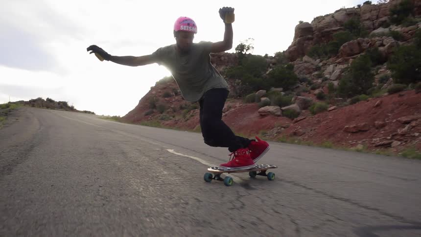 Man skateboarding down a paved road