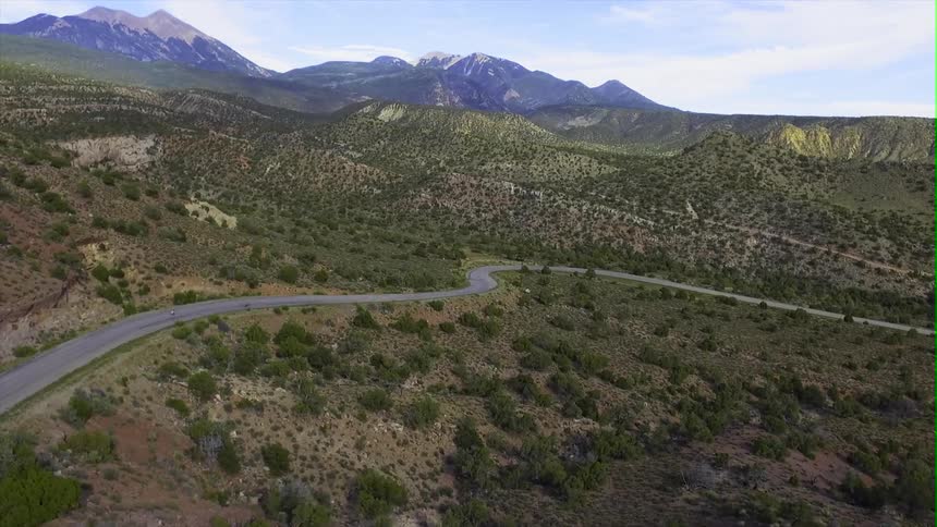 Bicyclists ride down a mountain road