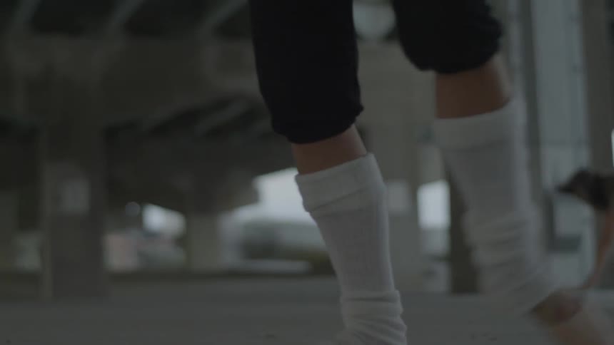 Dancers perform under a bridge