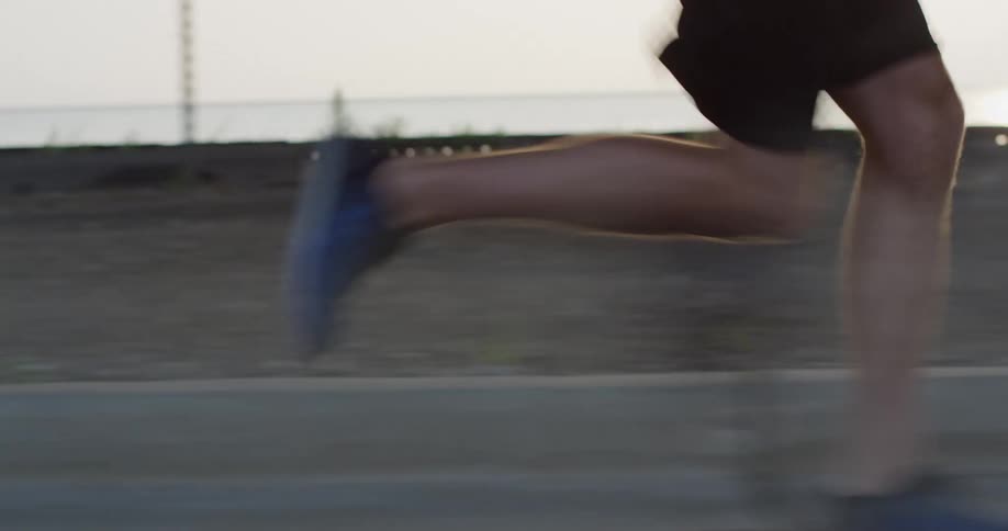 Closeup of a persons legs running on the city sidewalk