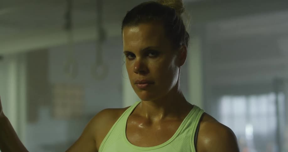A woman in a gym stares hard