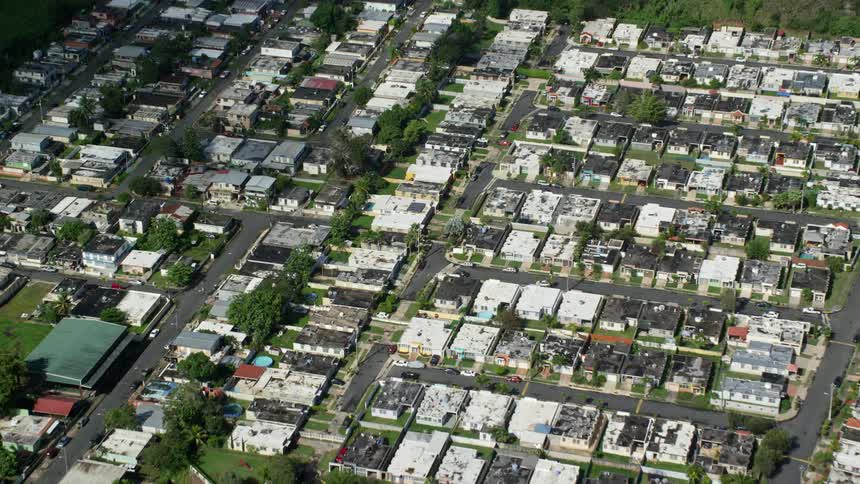 Aerial panorama of an urban city surrounded by mountains covered with forests