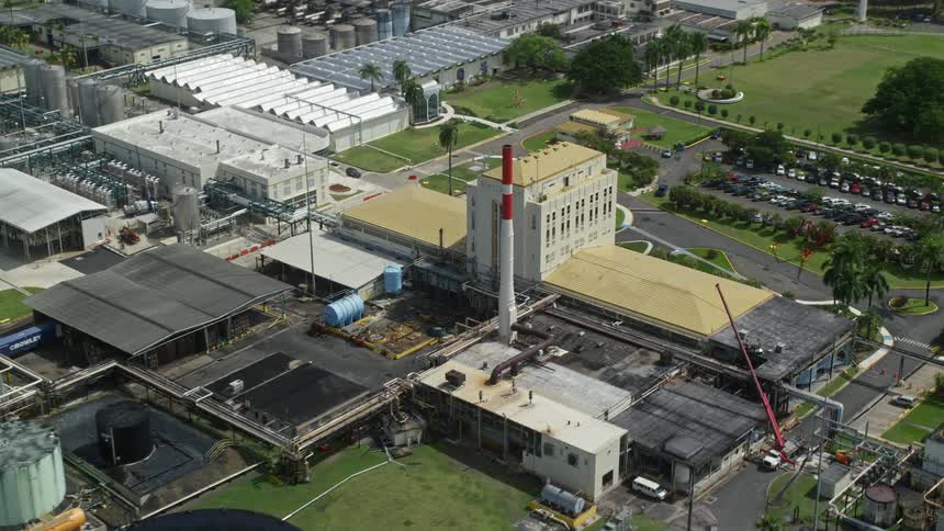 An industrial area with several buildings and storage compartments and close to the sea