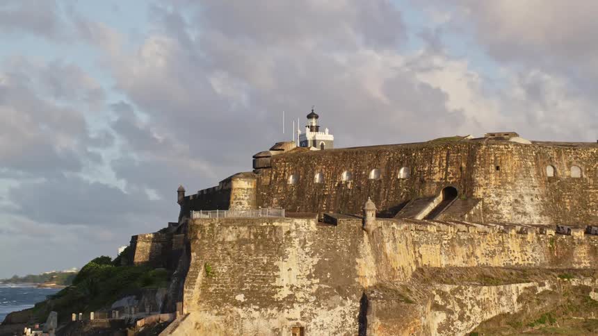 A large fort sits on a coast near a city