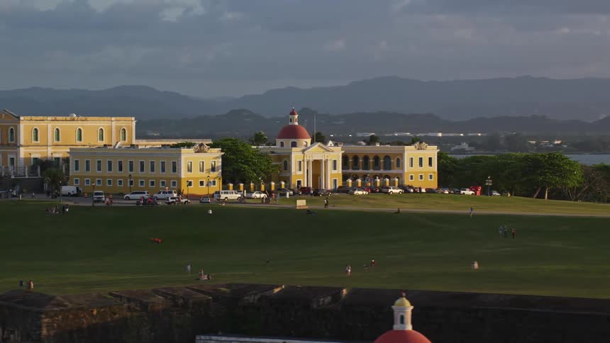 A complex of buildings sits on a plateau near the coast