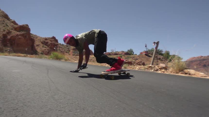 Man skateboarding down a paved road