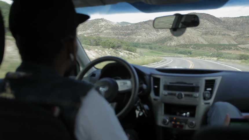 A man drives a car down a mountain road