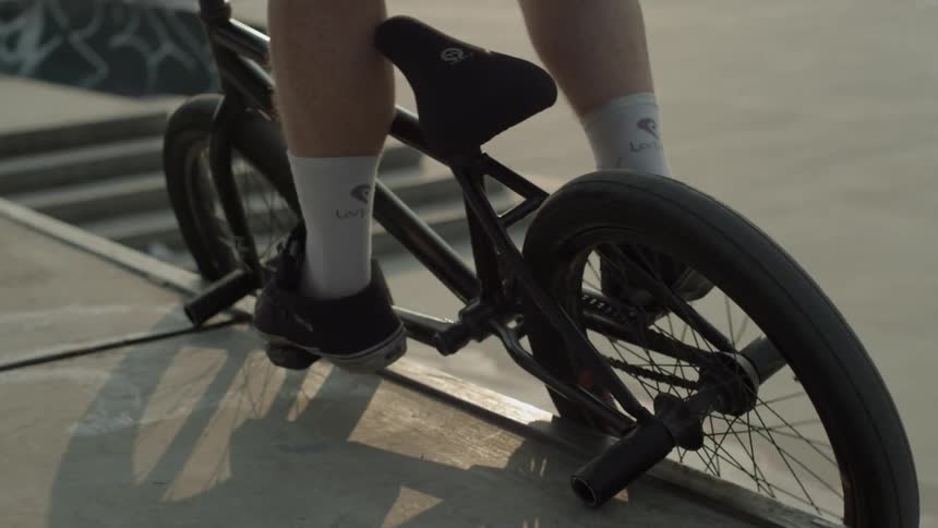 A person jumps their bike up a small flight of stairs then rides off