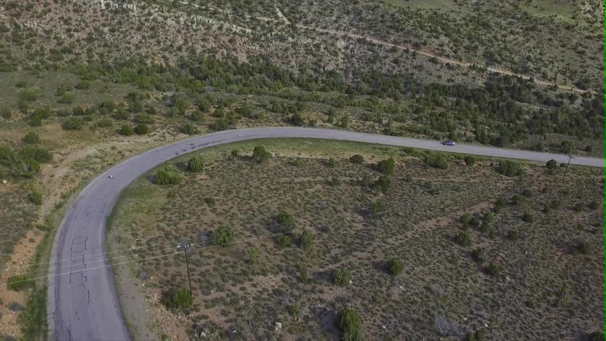 Cars travel down the winding road downhill
