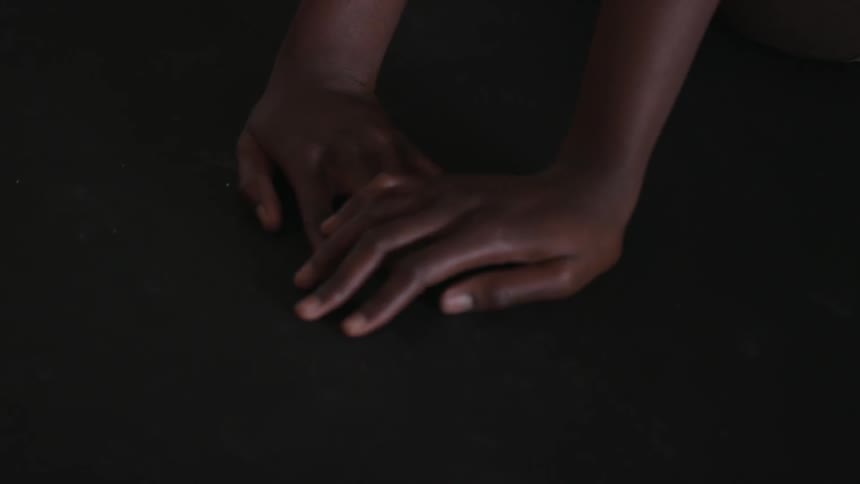 A person's hand rests on another before separating