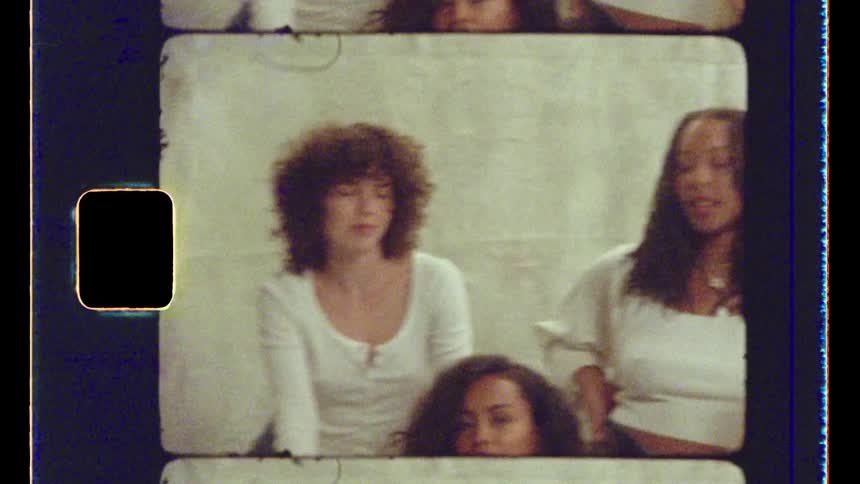 One guy and four women sit together in a room