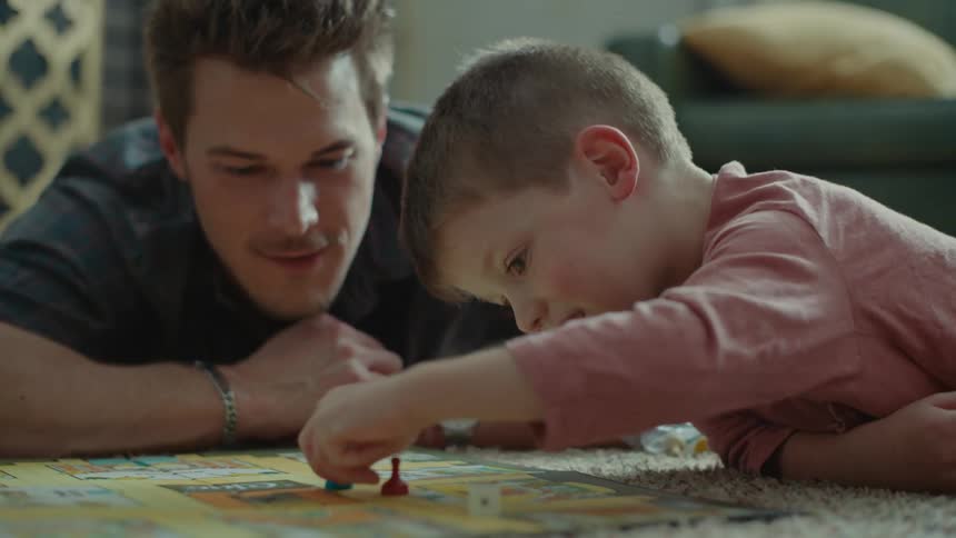 A man and a child play a board game