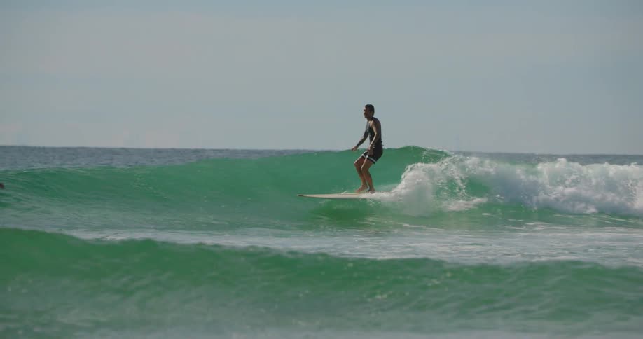 Man surfing a wave in a greenish sea