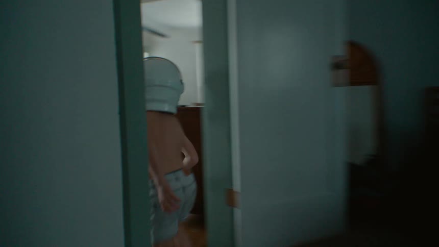 A boy runs around the house in a helmet