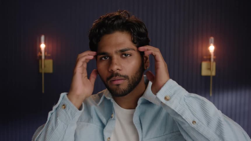 Portrait of a man adjusting his jacket and hair