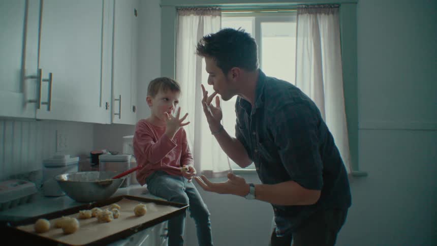 A father and son taste food as they cook