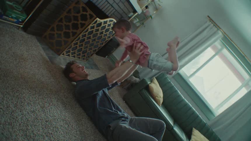 Son running towards his father who picks him up and lays him on the ground