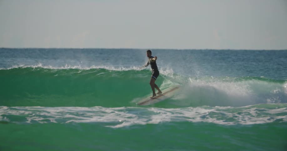 A man surfing on the sea at midday