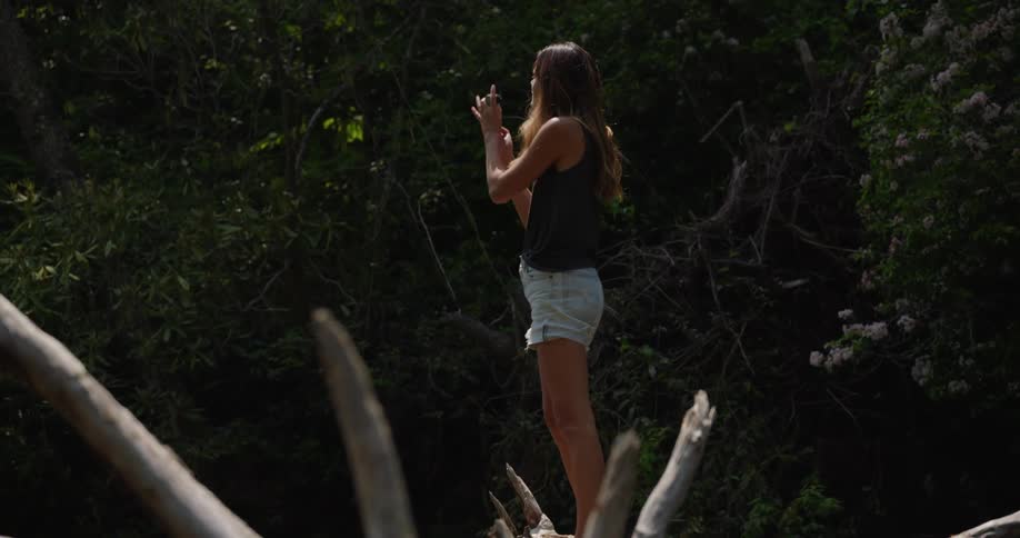 A white woman on a log to take a picture