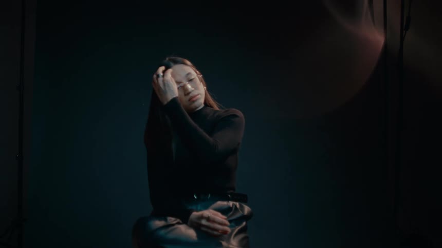 Model sitting on a stool in front of the camera