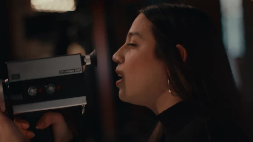 A woman using a camera in a room