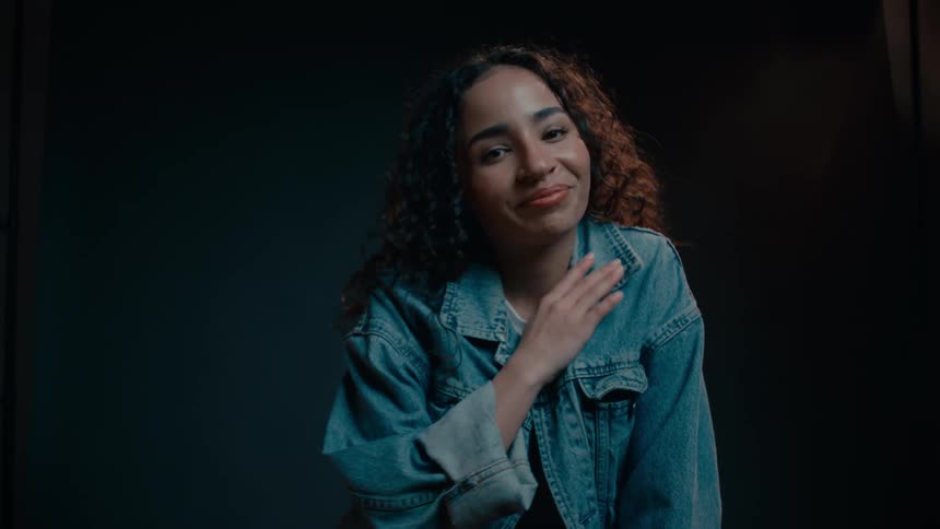 A model sits on a chair smiling