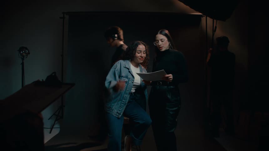 People organizing a fashion photo shoot in a dark room