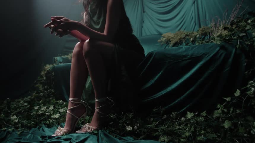 A woman sits on a couch covered in fabric