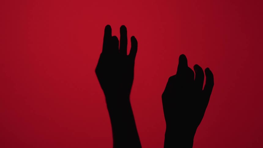 Silhouette of a womans hands on a red background