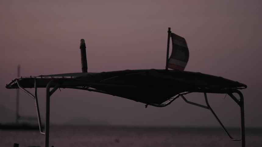 A tattered flag blowing in the wind at dusk