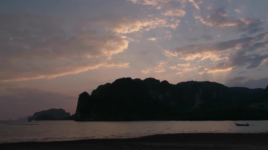 The sun sets over a calm beach
