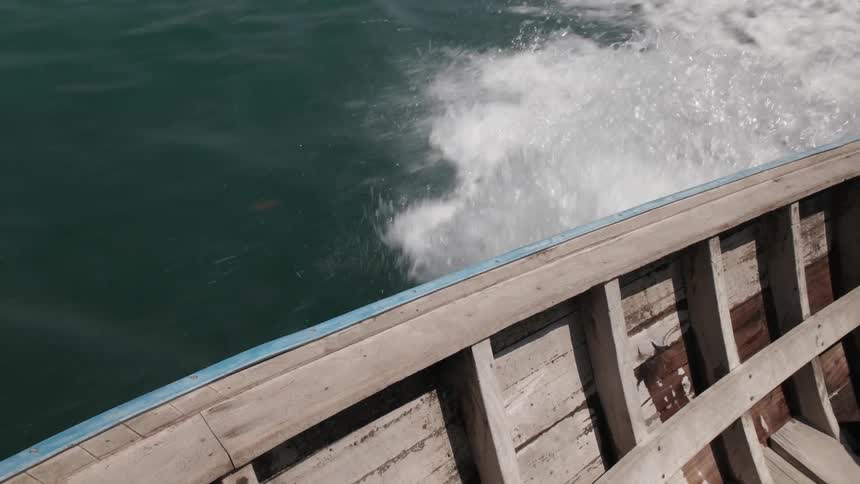 A wooden boat travels over the water
