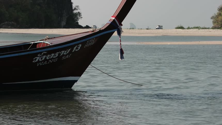 A boat sits docked along the beach shoreline