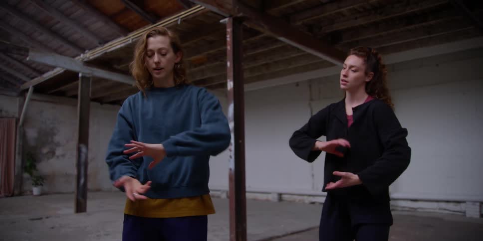 Two women indoors dancing