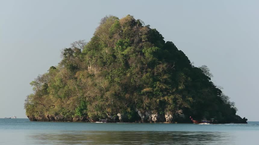 Boats traveling past a small overgrown island