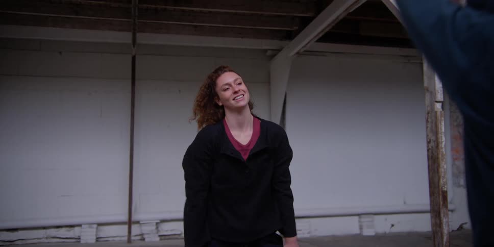 Two women moving their arms while practicing a dance choreography