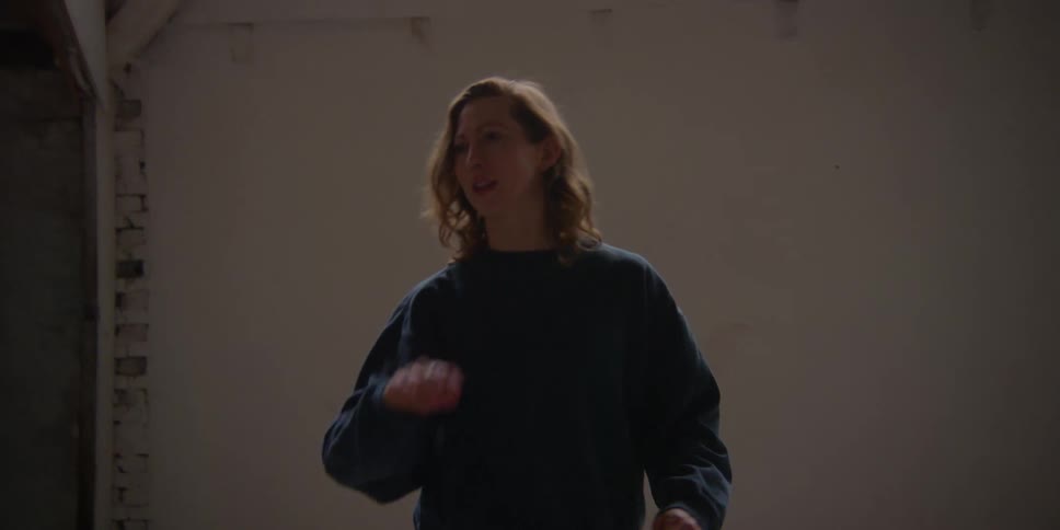 A woman shows a man some dance moves