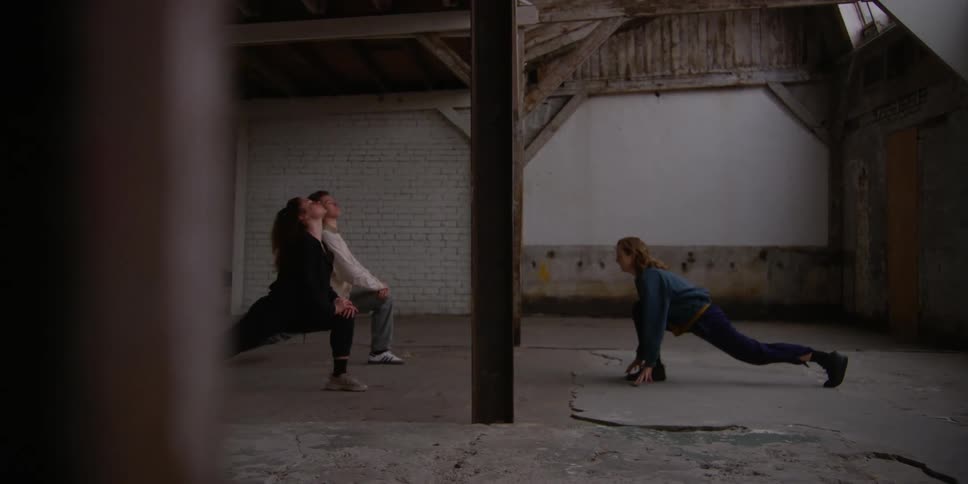 Dancers stretching inside an indoor space