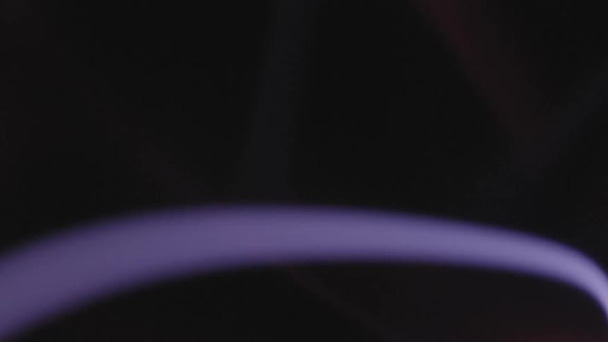 Close up of a purple electric arch against a black background